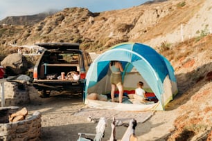 a man standing inside of a tent next to a van