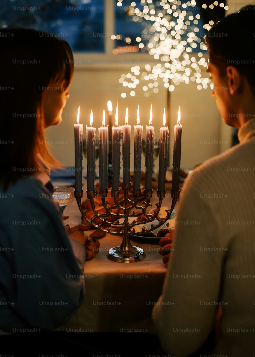 한 남자와 한 여자가 촛불 앞에 앉아 있다