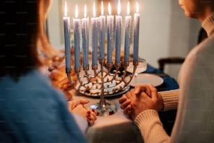 a man and a woman holding hands in front of a menorah