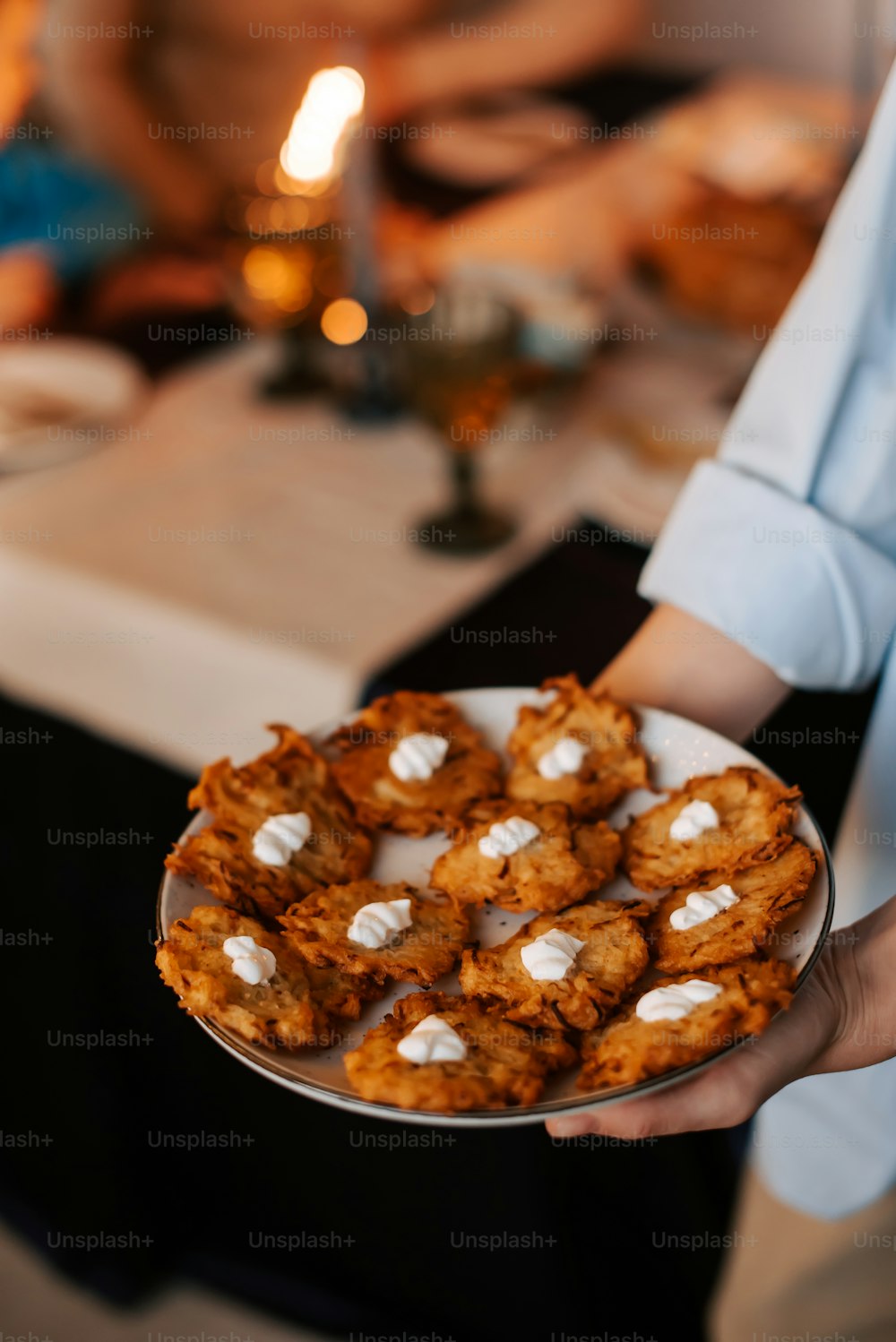 a person holding a plate of cookies with marshmallows