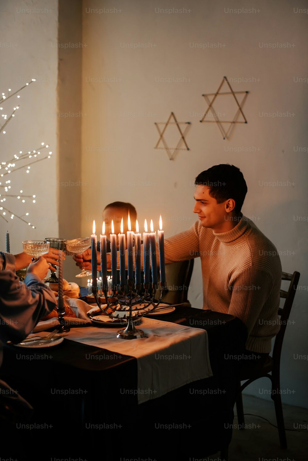 a man and a woman sitting at a table with a lit menorah