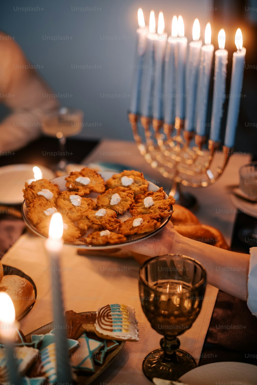 a table topped with a plate of cookies and candles