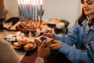 a man and a woman exchanging a gift at a table