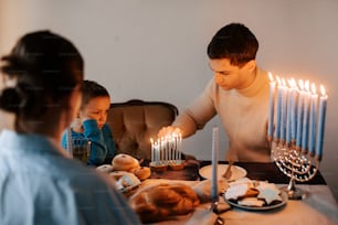a man lighting candles on a table with a little girl