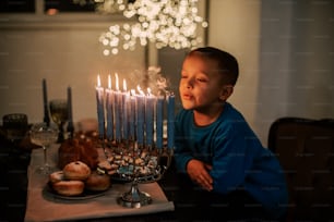 a young boy blowing out candles on a cake