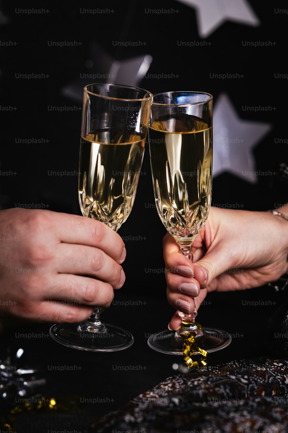 a close up of two people holding wine glasses