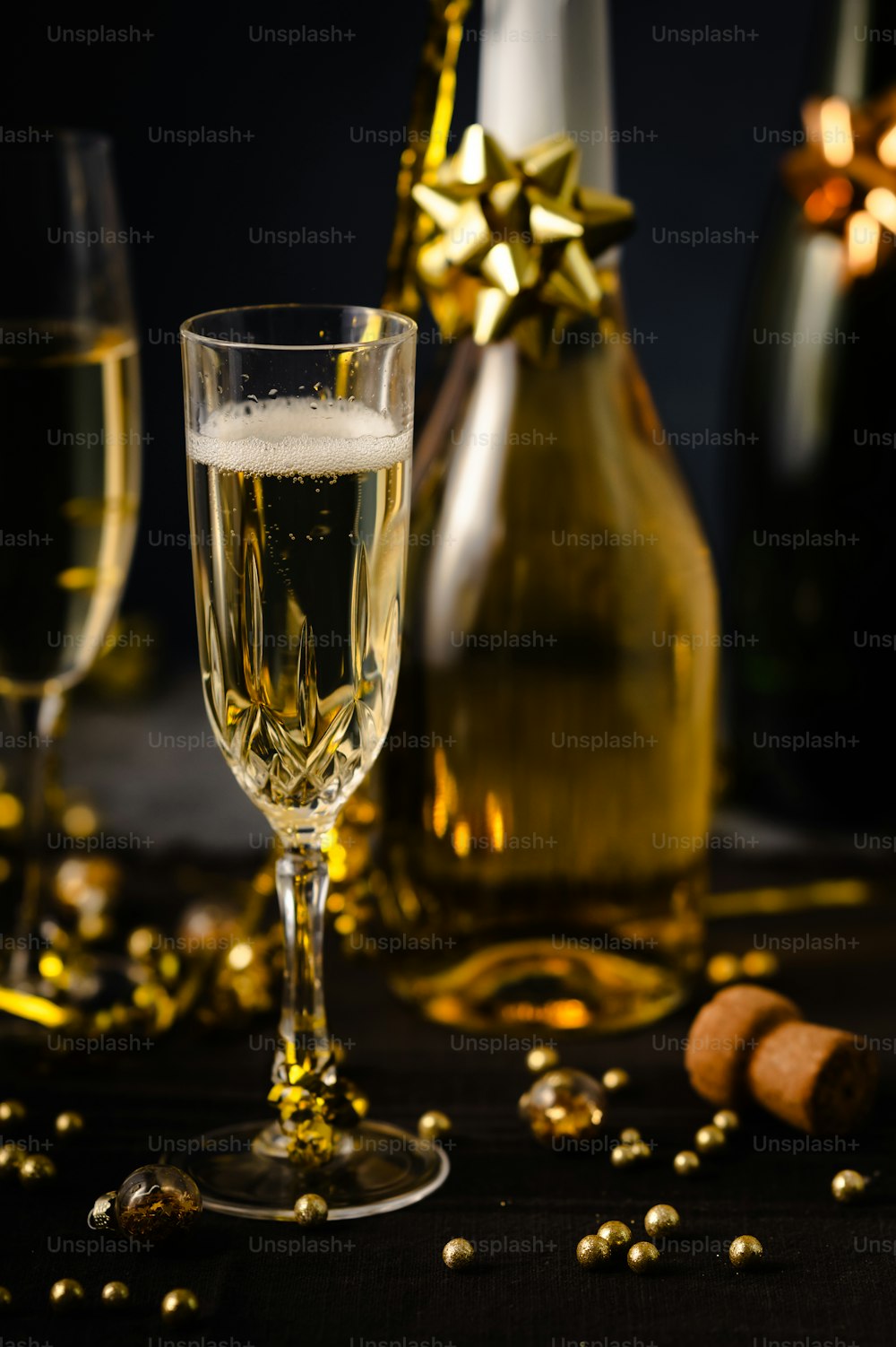 シャンパンのボトルの隣にシャンパンのグラス