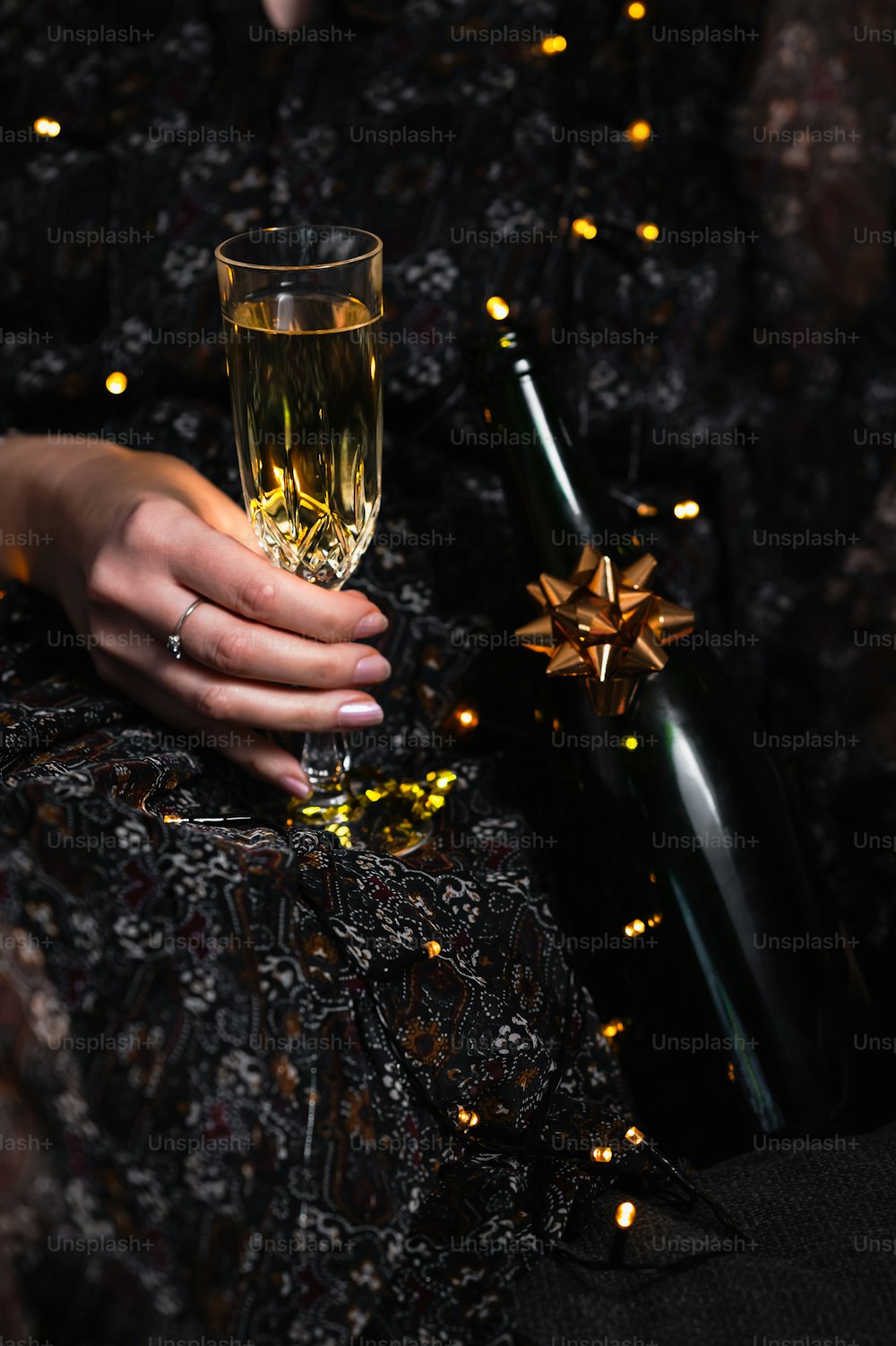 una mujer sosteniendo una copa de champán y una botella de vino