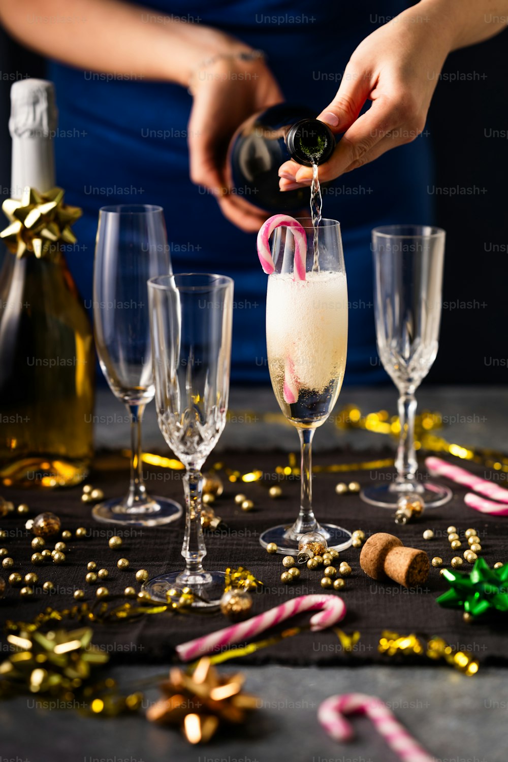 a person pouring champagne into a wine glass