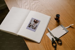 an open book on a table with a pair of scissors