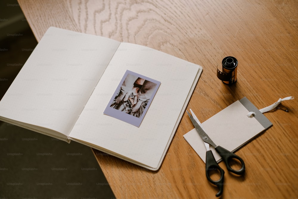 un livre ouvert sur une table avec une paire de ciseaux