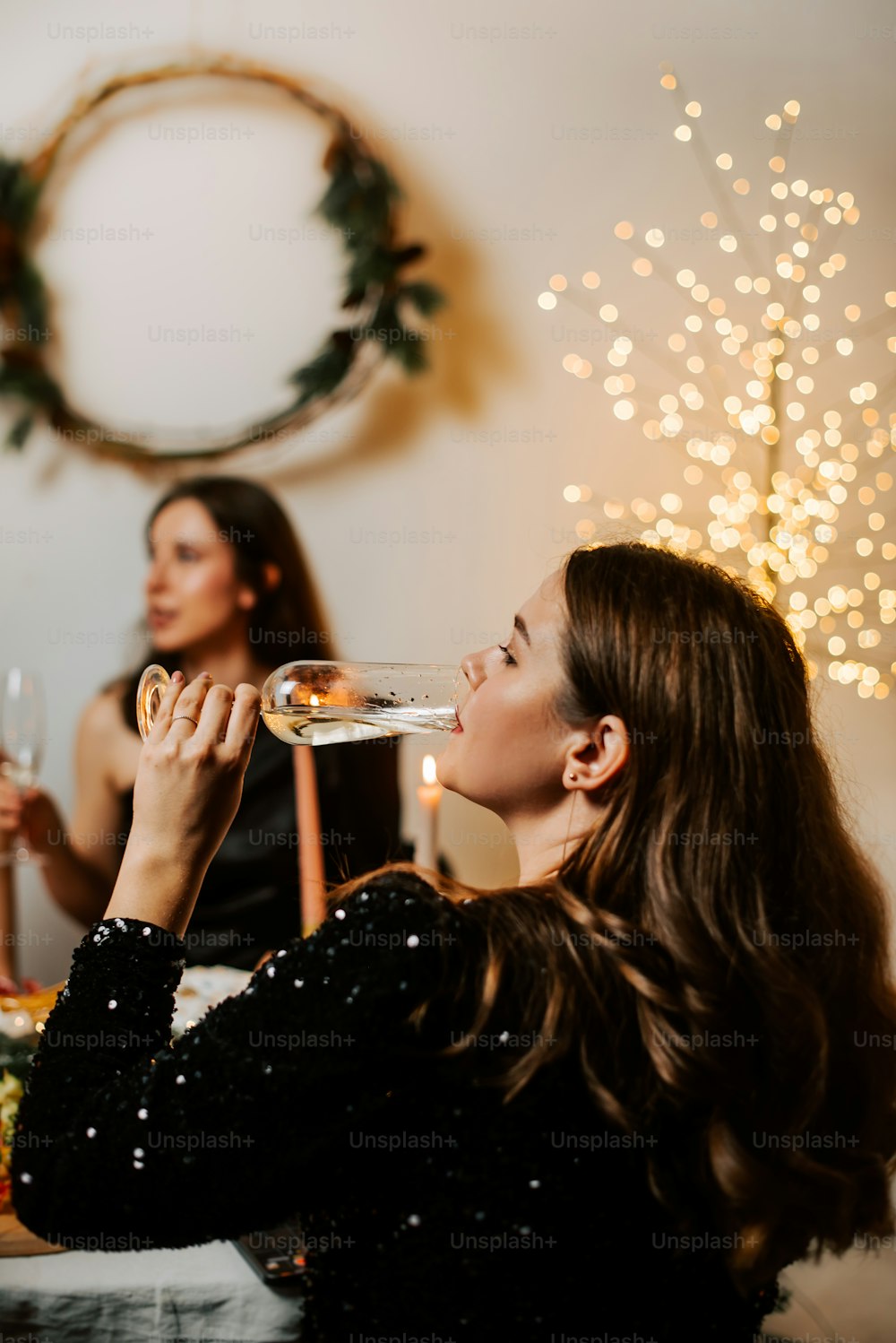 two women sitting at a table drinking wine