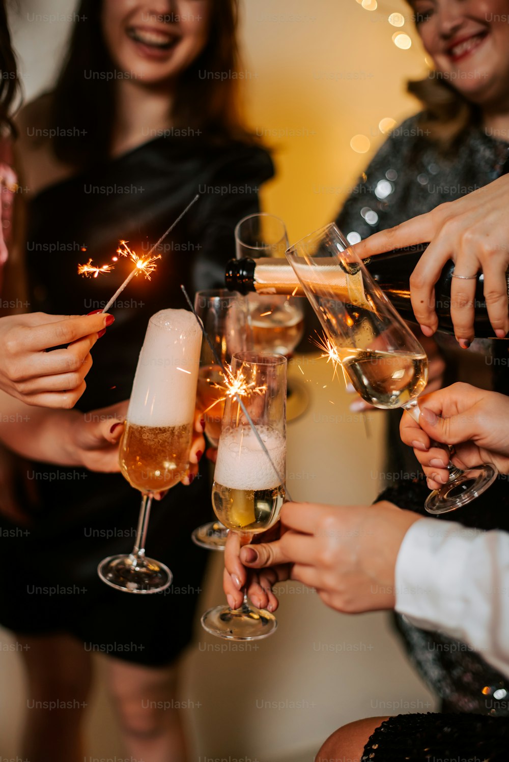 a group of people holding wine glasses with sparklers in them