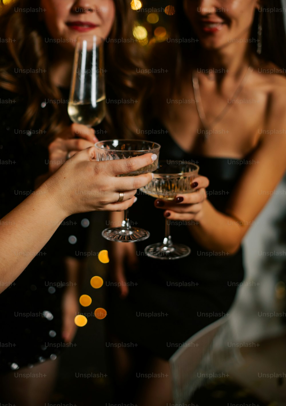 와인잔을 들고 나란히 서 있는 두 명의 여성