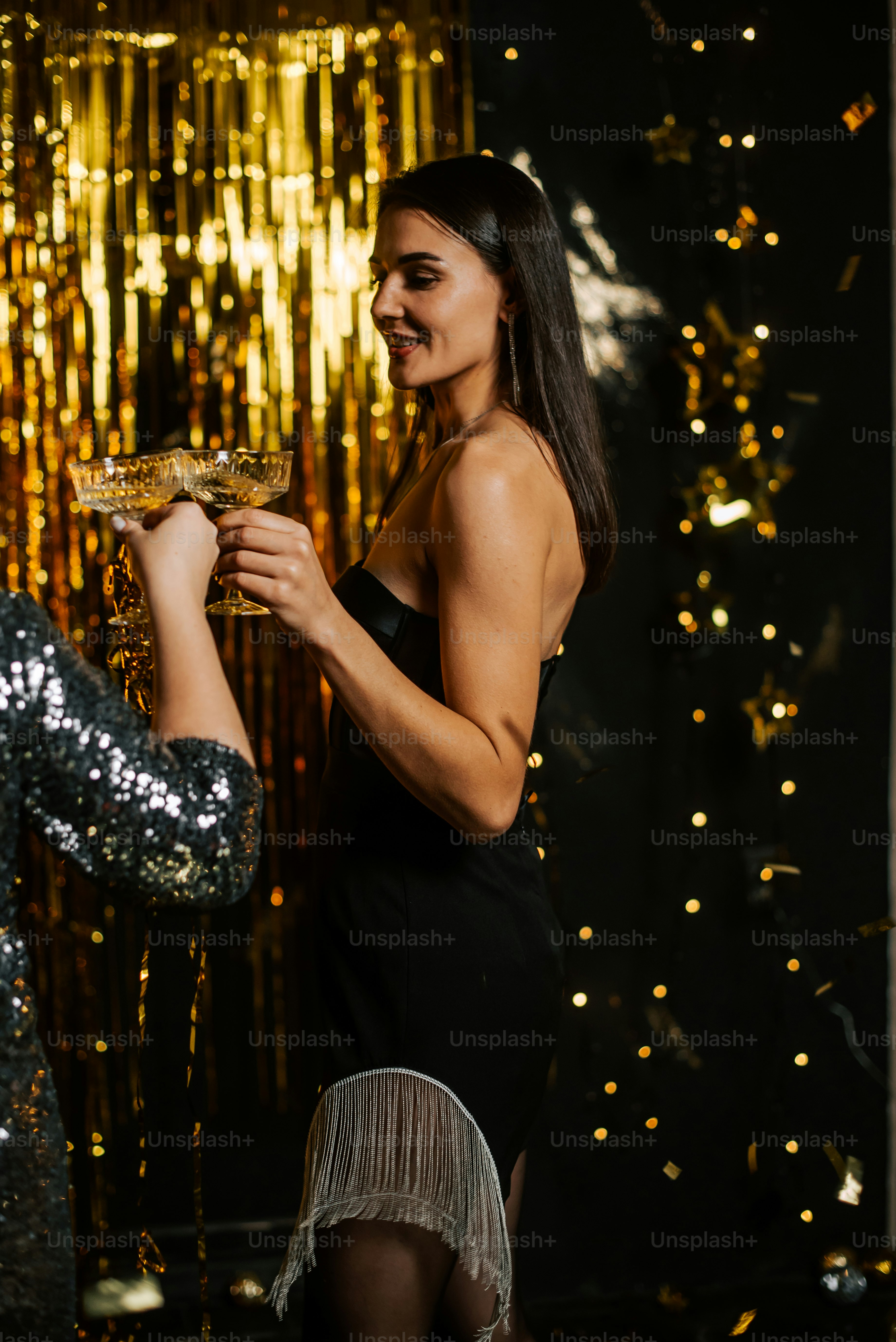 a woman in a black dress holding a glass of champagne