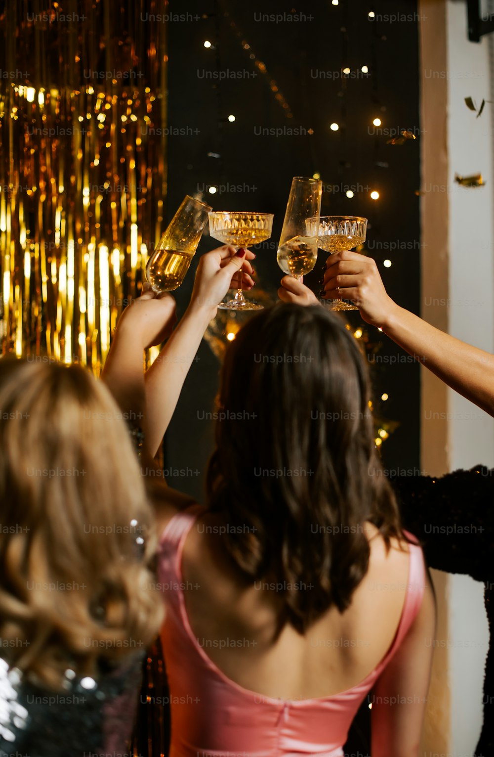 a group of women toasting with wine glasses