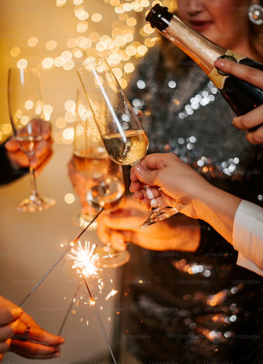 a group of people holding wine glasses and sparklers
