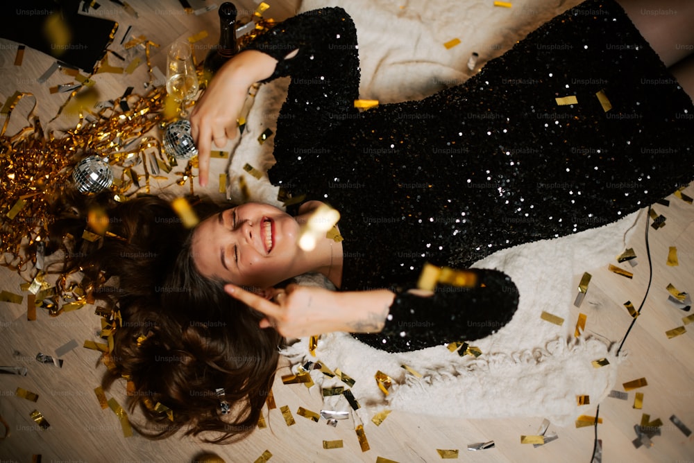 a woman laying on the floor surrounded by confetti