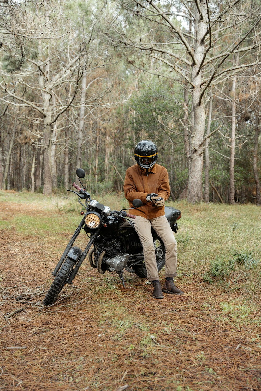 Ein Mann sitzt auf einem Motorrad im Wald