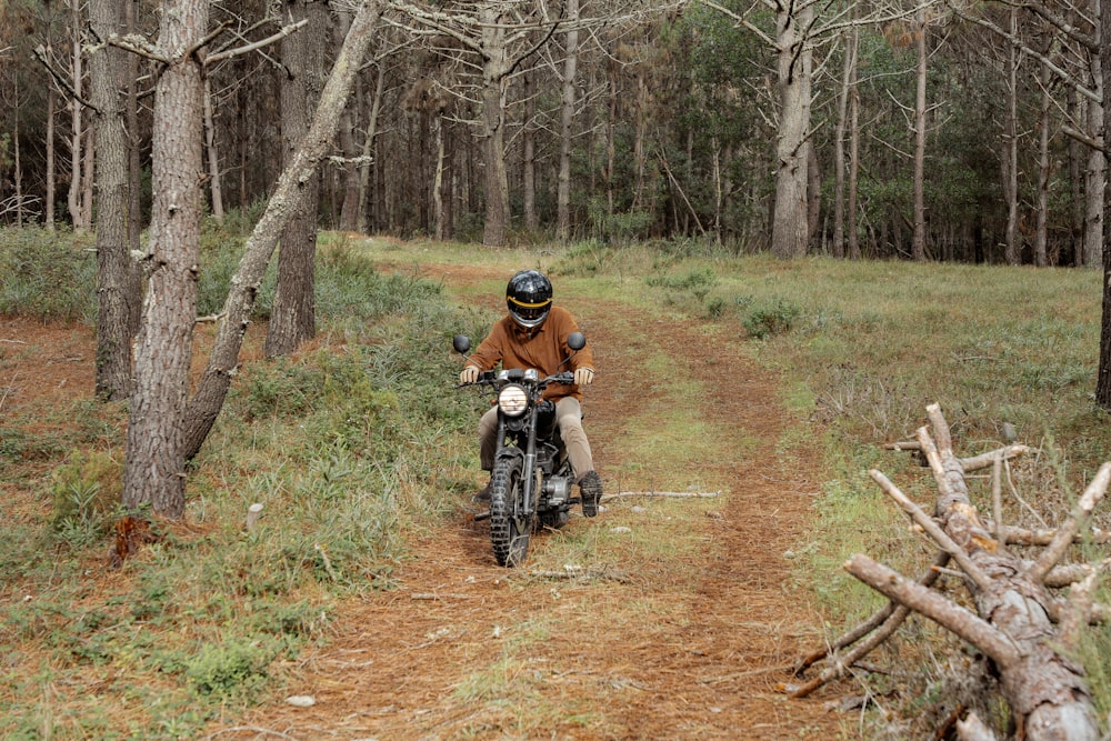 um homem pilotando uma motocicleta por uma estrada de terra