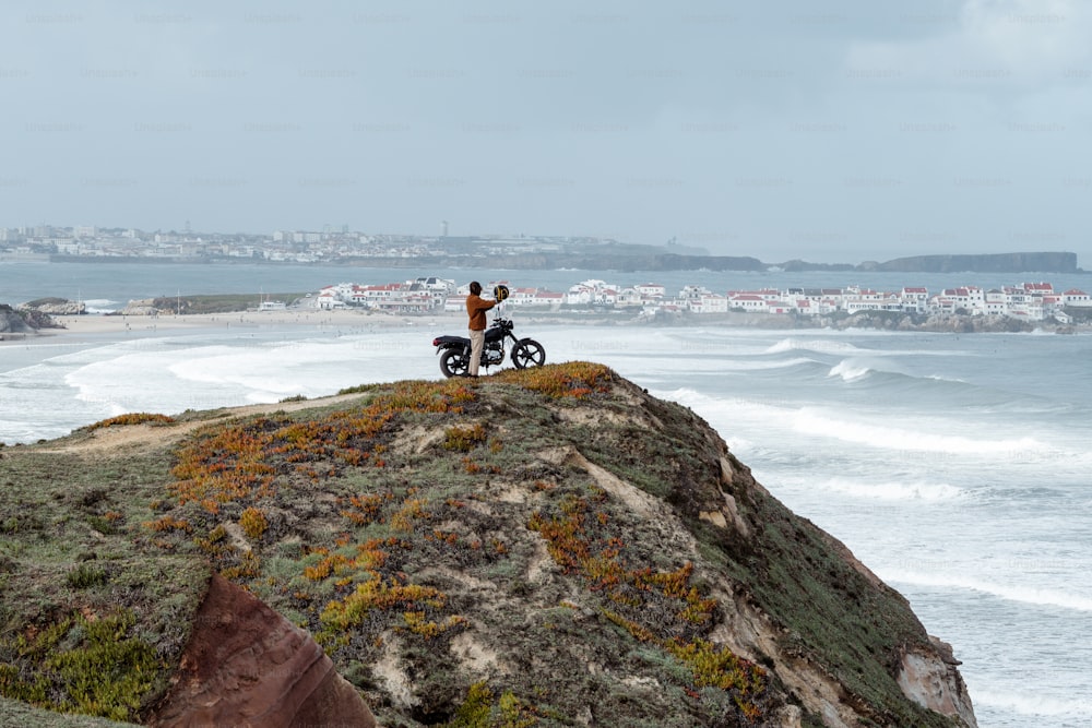 duas pessoas em cima de uma rocha perto do oceano