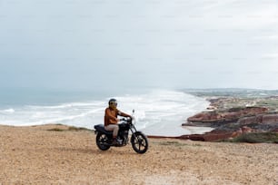 Un homme conduisant une moto au sommet d’une plage de sable