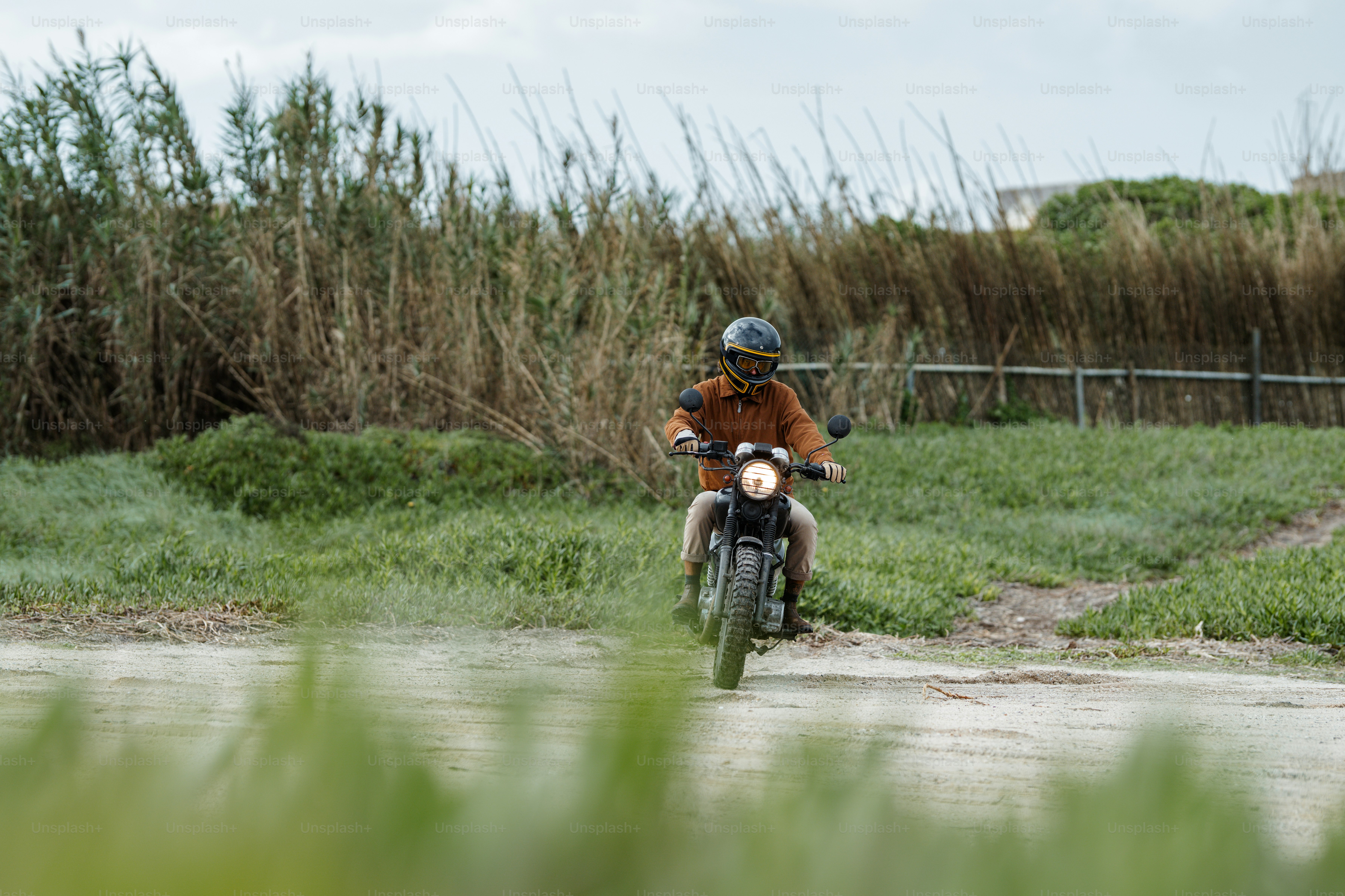 un uomo in sella a una motocicletta lungo una strada sterrata
