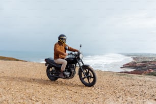 a man riding a motorcycle on top of a sandy beach