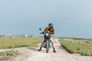 a man riding a motorcycle down a dirt road