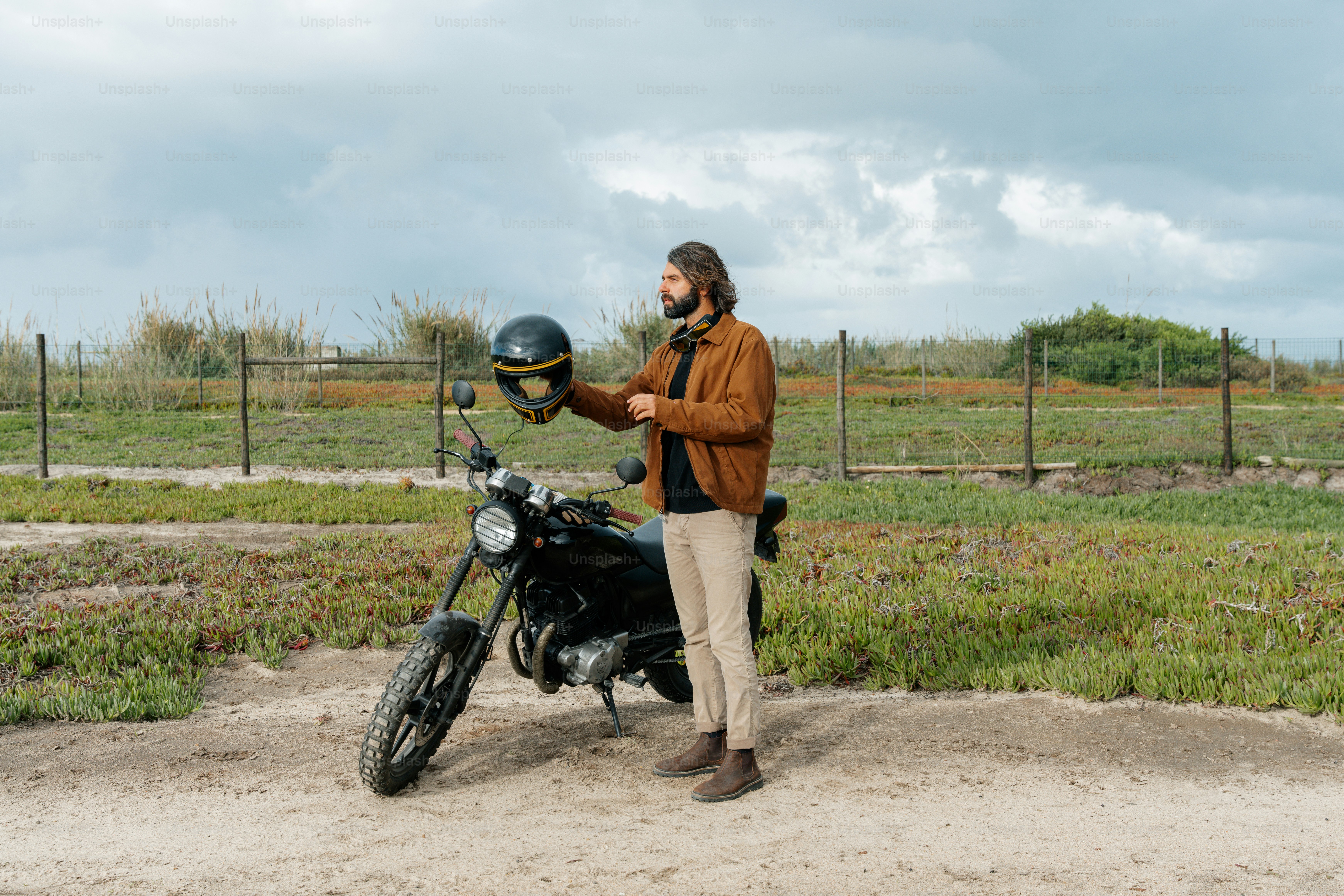 a man standing next to a motorcycle with a helmet on