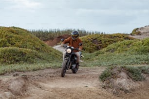 a man riding a motorcycle down a dirt road