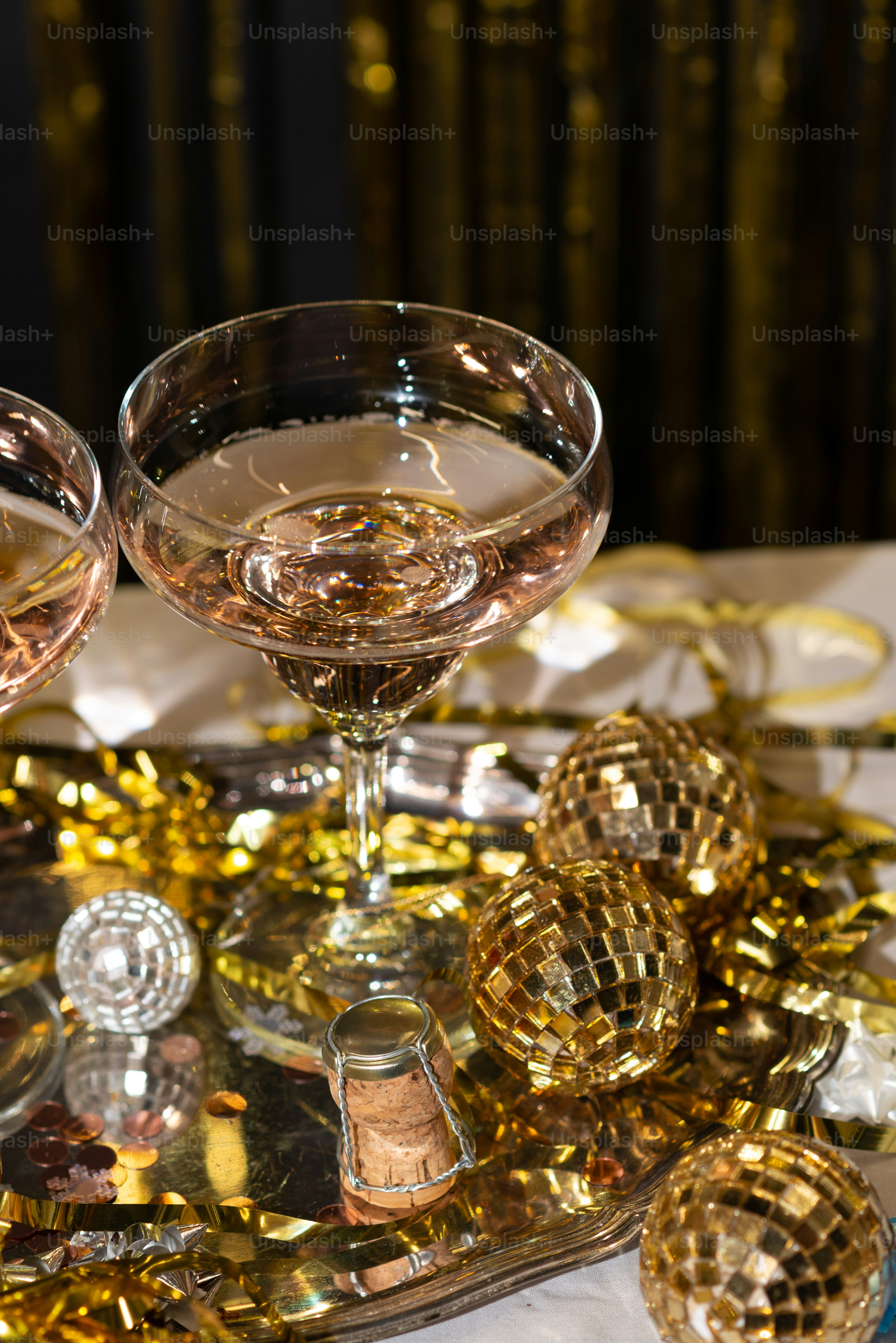 Deux verres de vin sur une table avec des confettis dorés