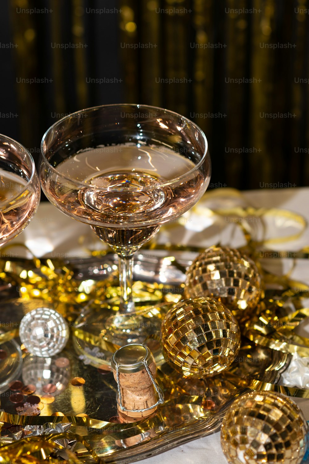 two glasses of wine on a table with gold confetti