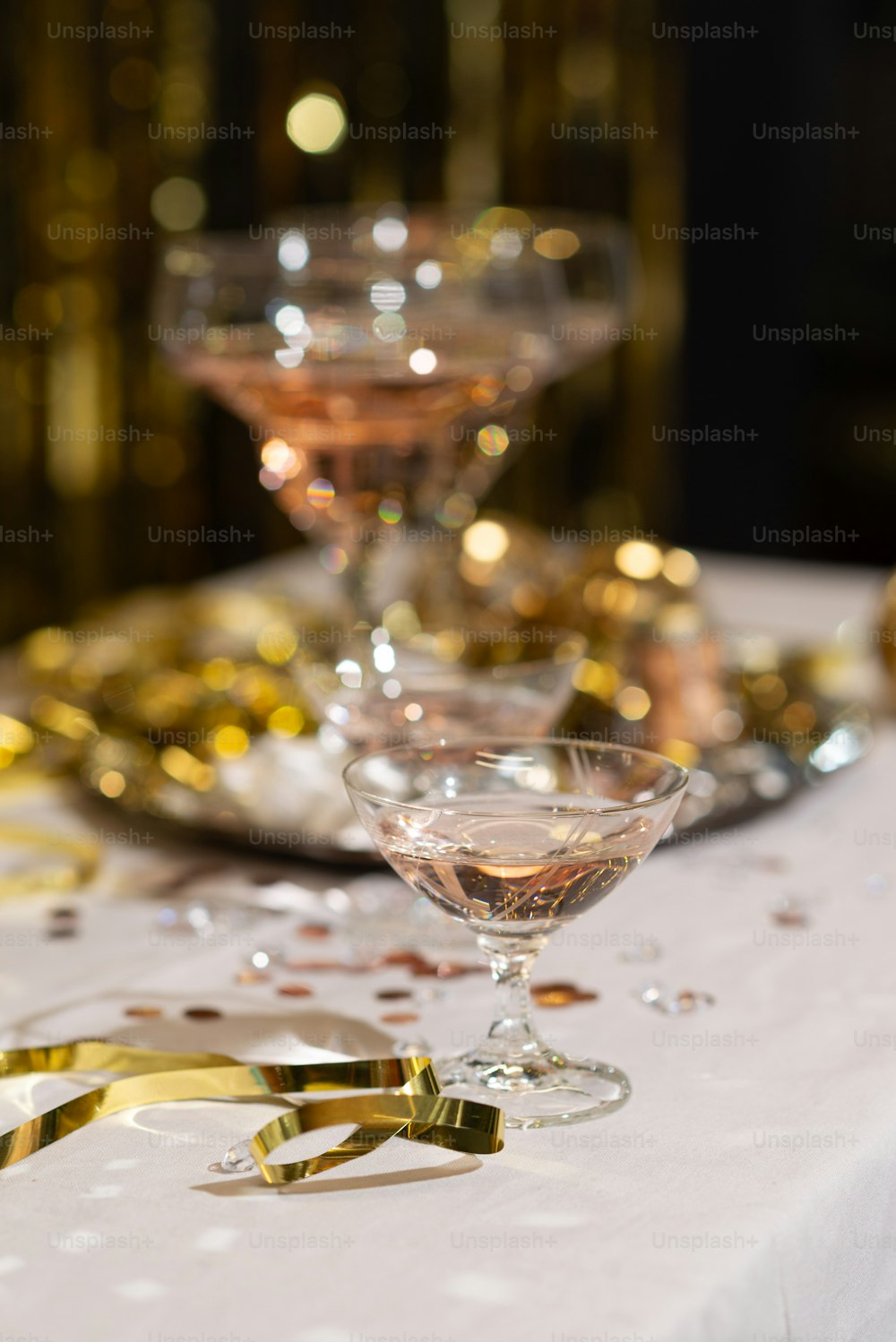 a table topped with glasses of champagne and confetti