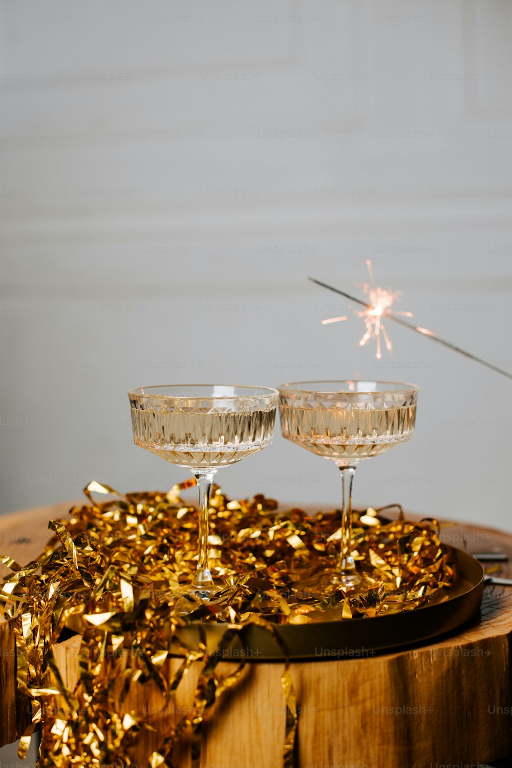 Deux coupes de champagne avec un cierge magique en arrière-plan