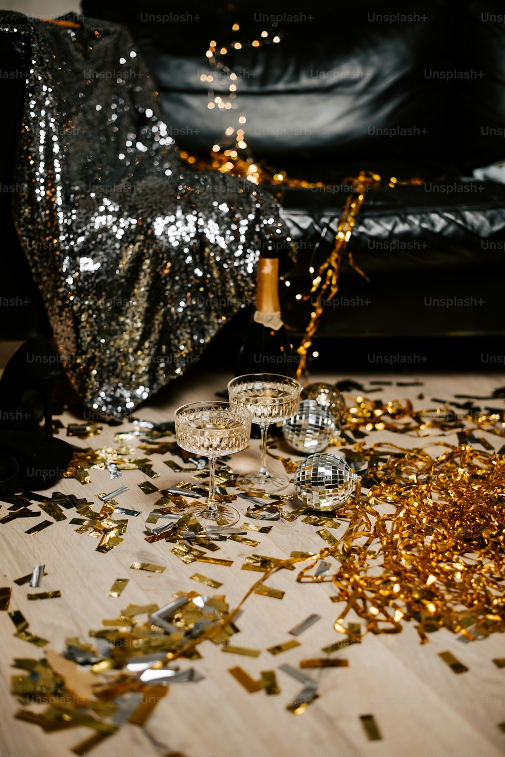 a table topped with glasses and confetti on top of a table