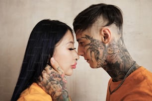 a man and a woman with tattoos on their faces