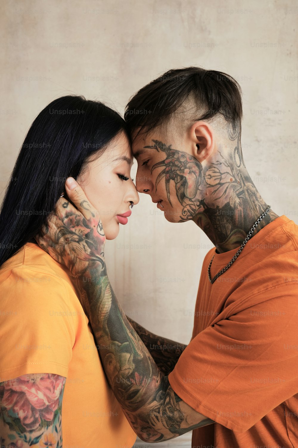 a man and a woman with tattoos on their faces
