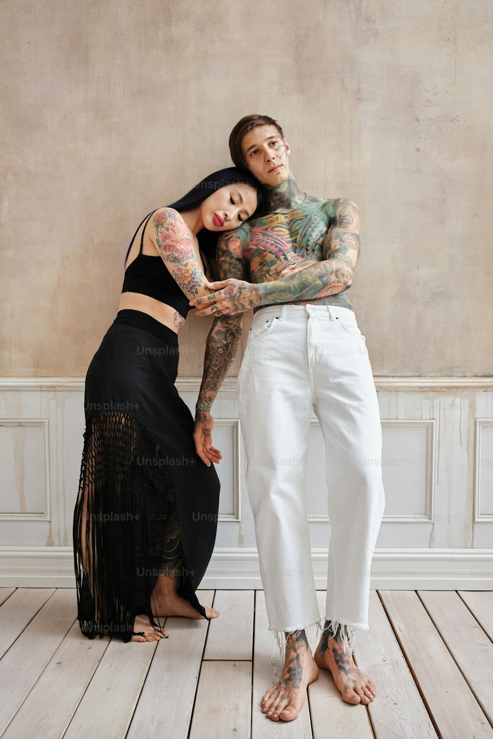 a tattooed man and a tattooed woman posing for a photo