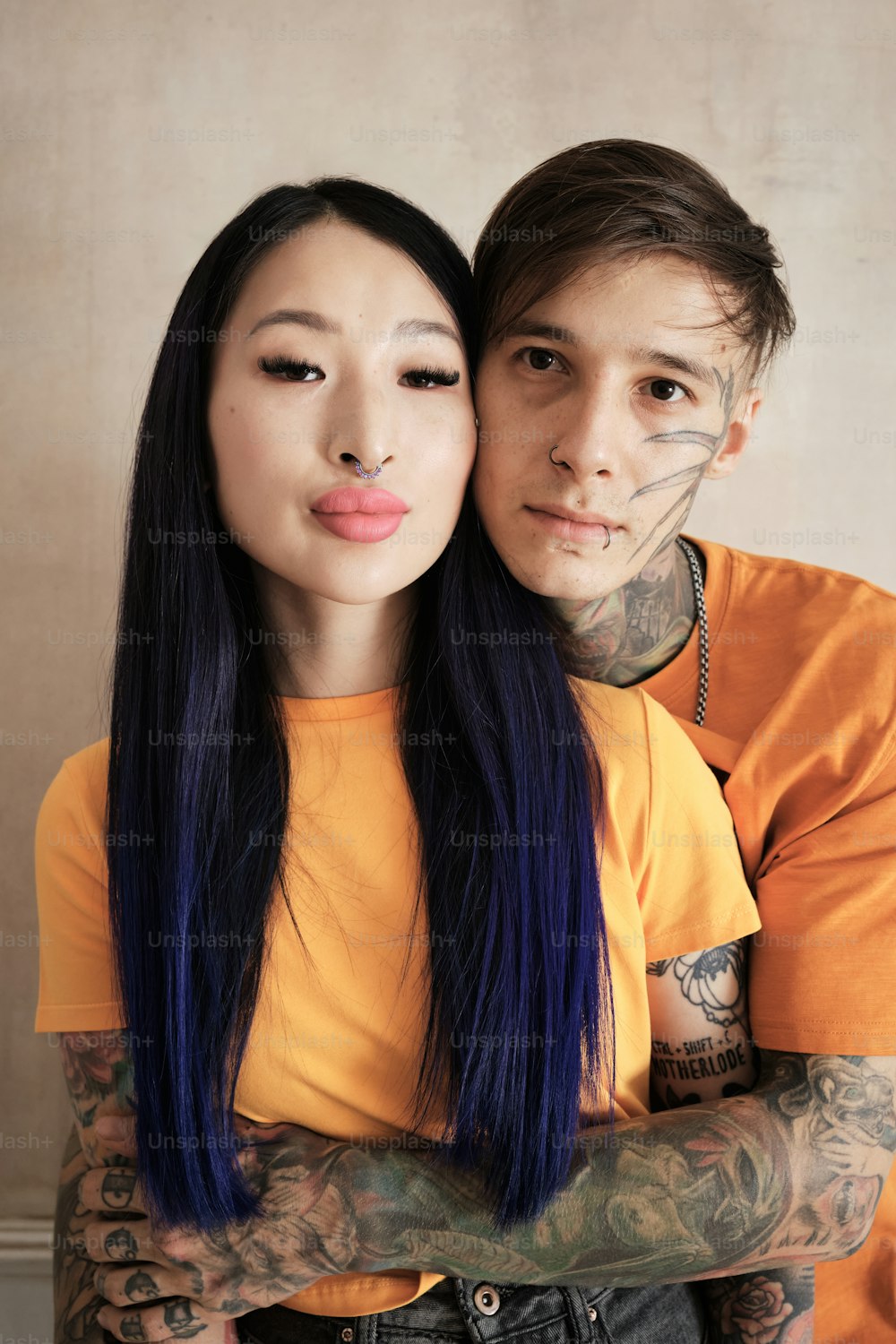 un homme et une femme avec des tatouages sur les bras