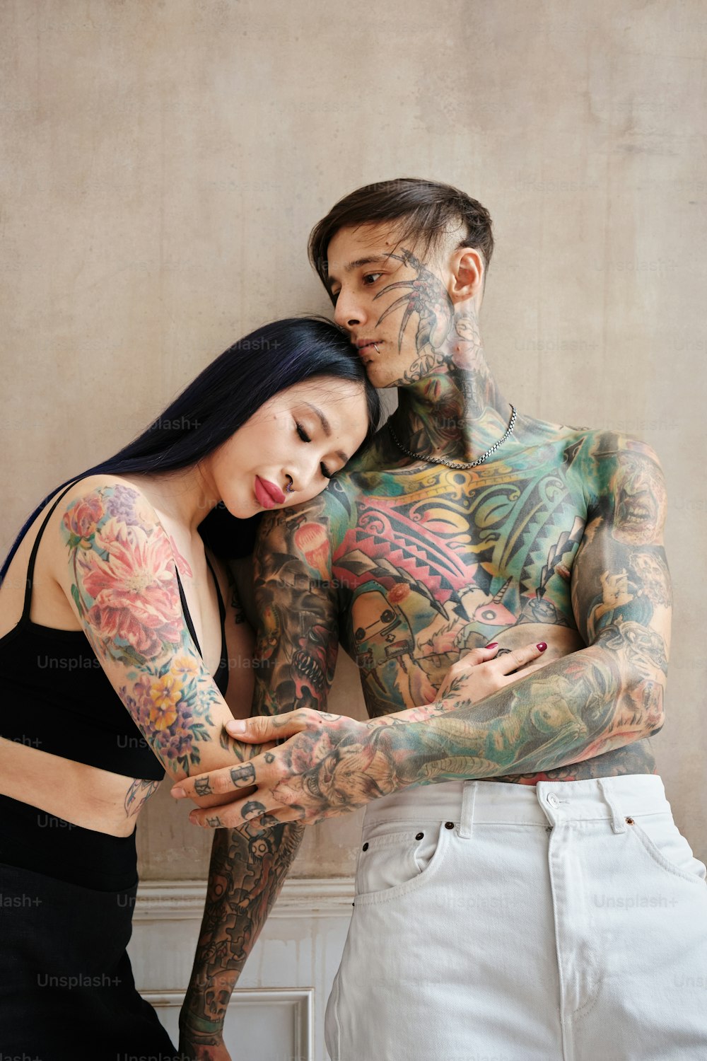 a man and a woman with tattoos on their bodies