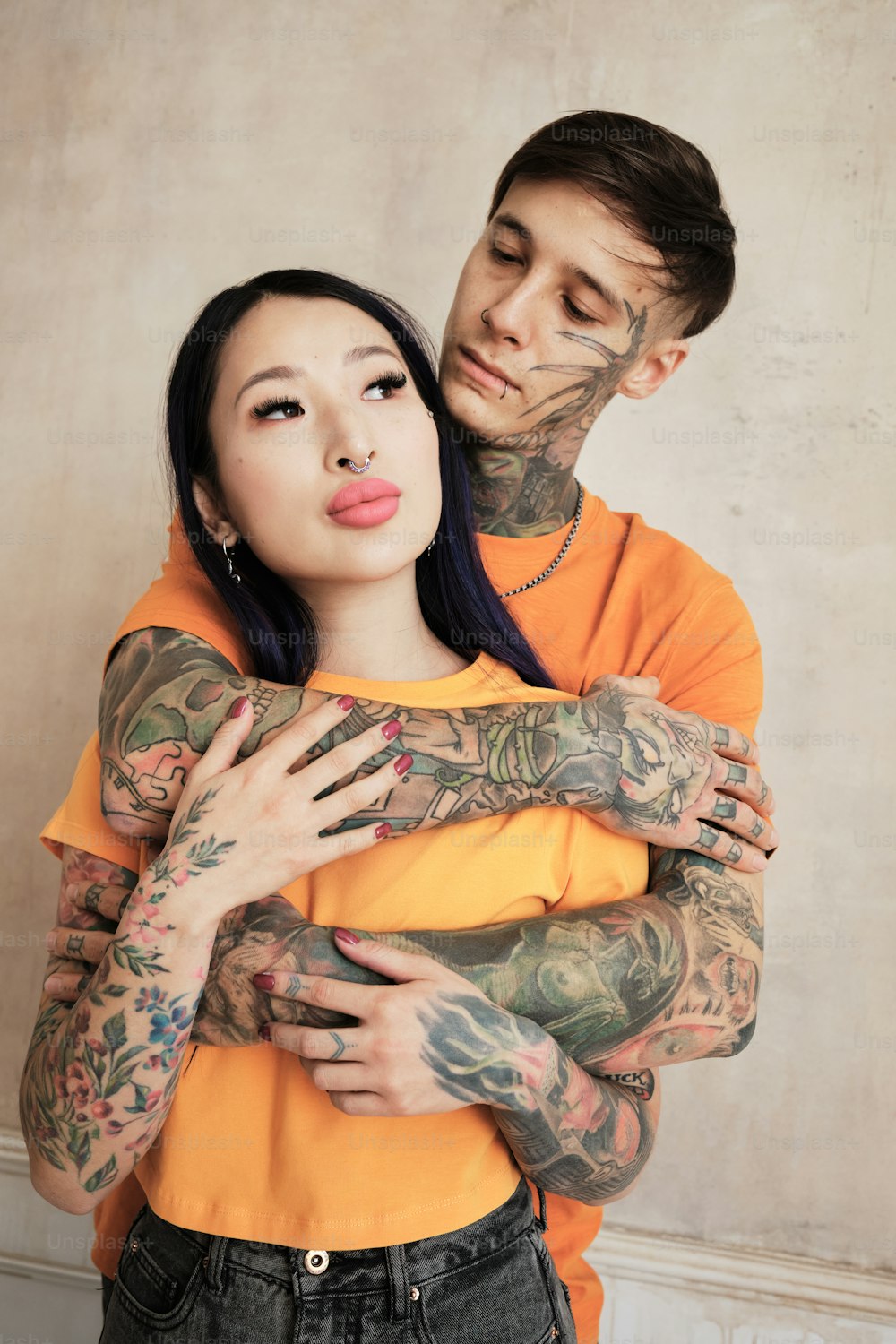 un homme et une femme avec des tatouages sur les bras