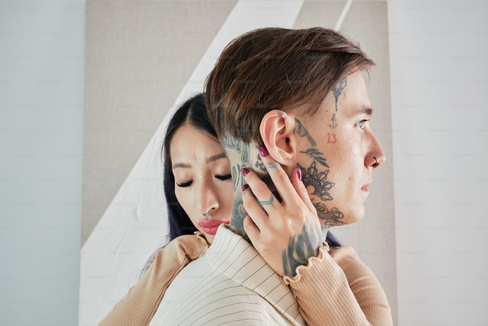 un hombre y una mujer con tatuajes en la cara