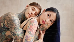 un hombre y una mujer con tatuajes en los brazos