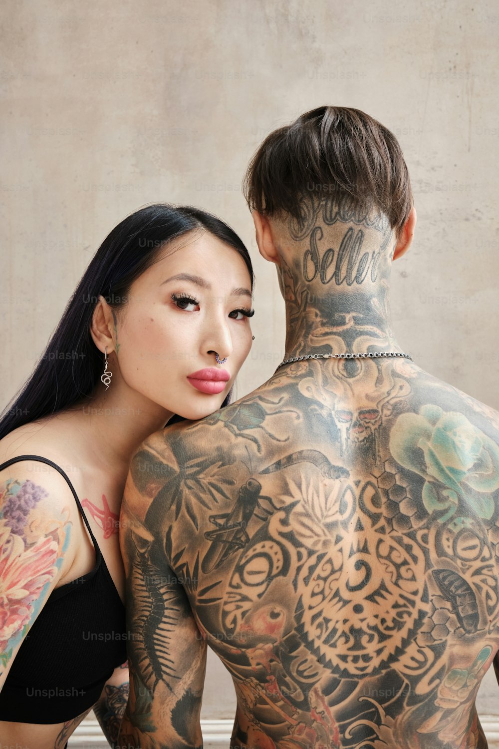 a man and a woman with tattoos on their backs