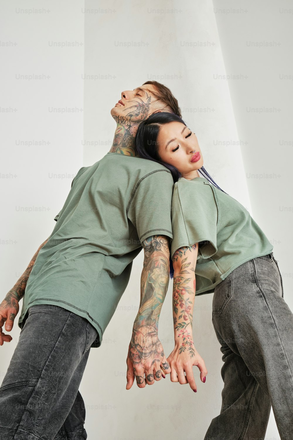 um homem e uma mulher com tatuagens nos braços