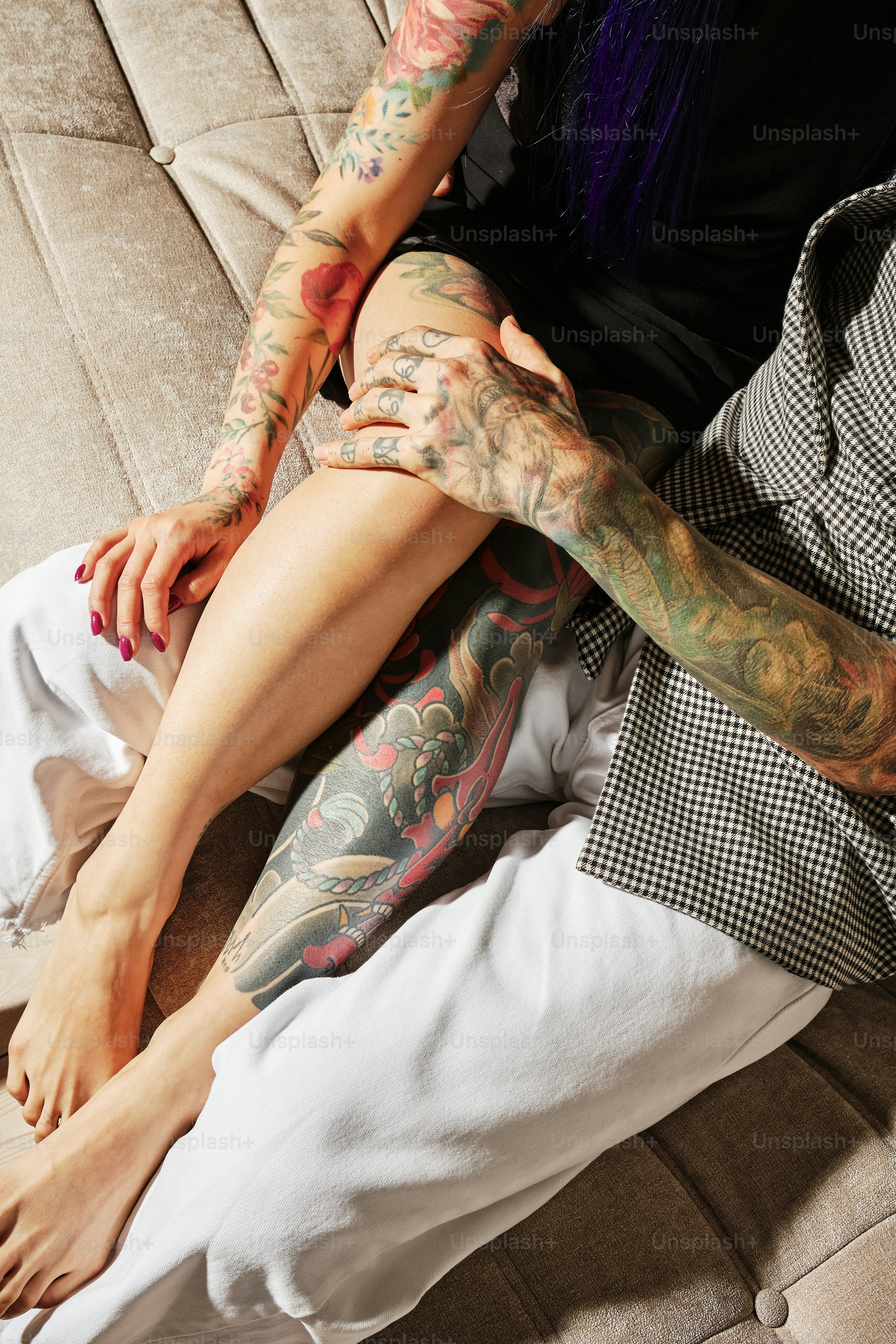 una donna con tatuaggi seduta su un divano