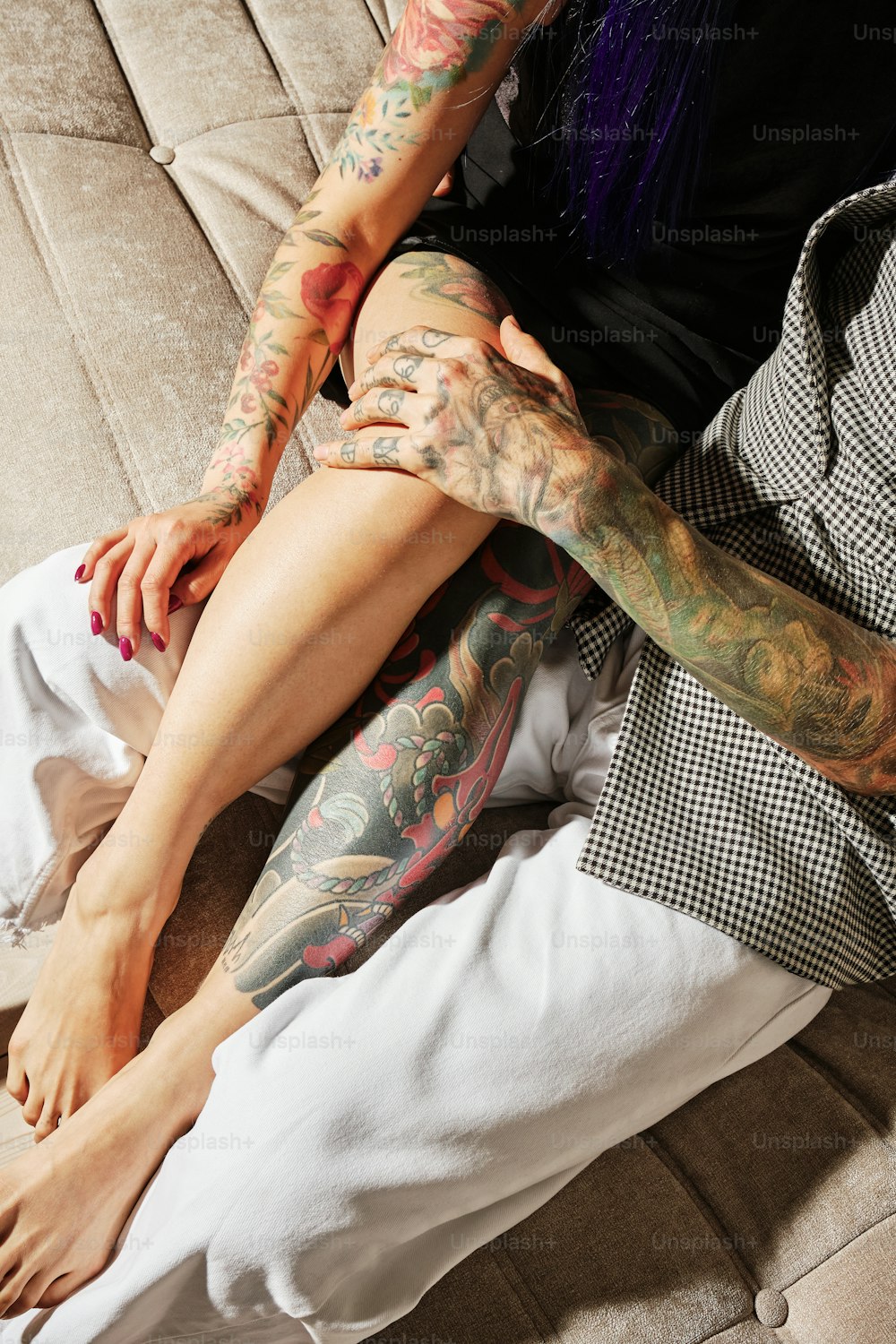 una donna con tatuaggi seduta su un divano