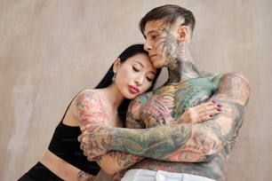 Un hombre y una mujer tatuados abrazándose
