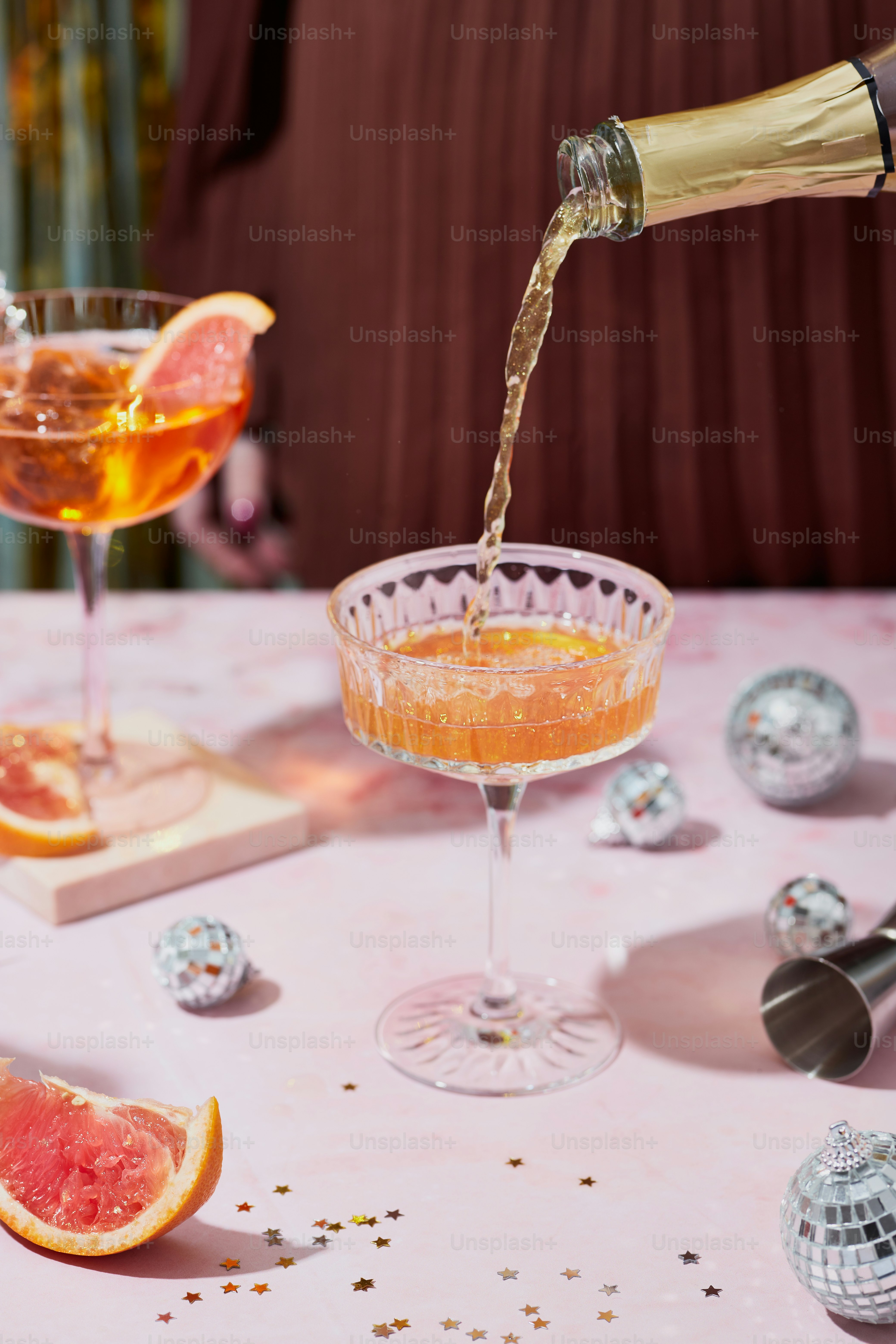 a person pouring a drink into a wine glass